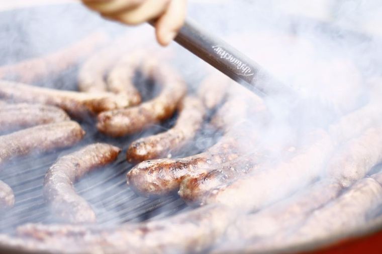 Des saucisses qu'on retourne sur le grill
