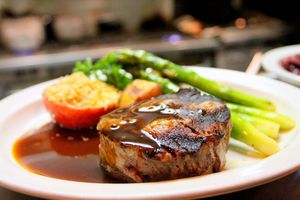 Un filet de bœuf nappé de sauce, asperges vertes